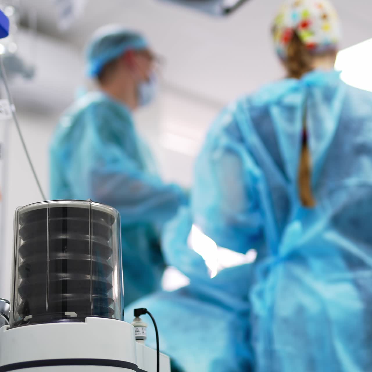 Lung ventilation apparatus in surgery theatre. Close up. Surgeons conducting operation at backdrop in blur