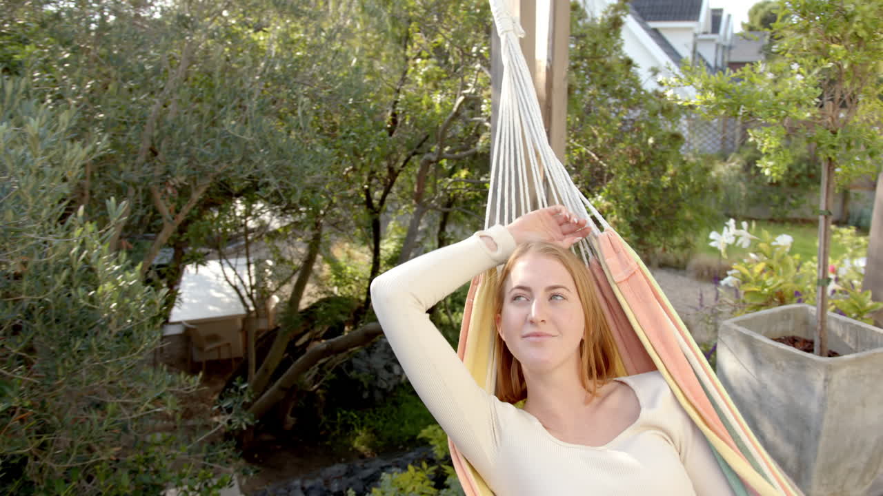 Relaxing in hammock, woman enjoying peaceful time outdoors in garden, copy space