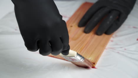 applying wood stain to a plank