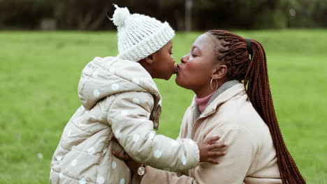 love, nature and mother kissing her child in park