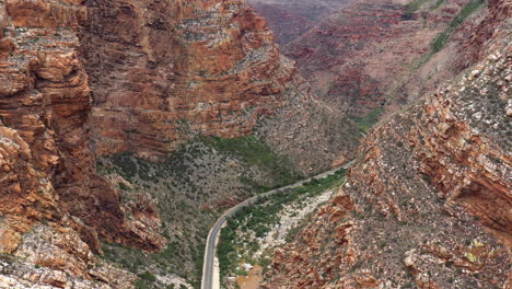 beautiful winding road crossing a rocky canyon in south africa aerial view