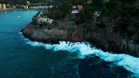 Port-De-Sóller-Wellen,-Die-Während-Des-Sommersturms-Auf-Klippen-Krachen-Dramatische-Neigung-Nach-Unten-Luftbild-Auf-Mallorca