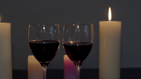 dos copas de vino en una mesa iluminada con velas