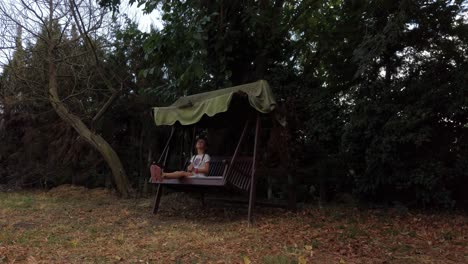 young girl taking time to swing on a seat under a canopy