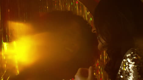 close up of two women dancing in nightclub bar or disco drinking alcohol with sparkling lights 13