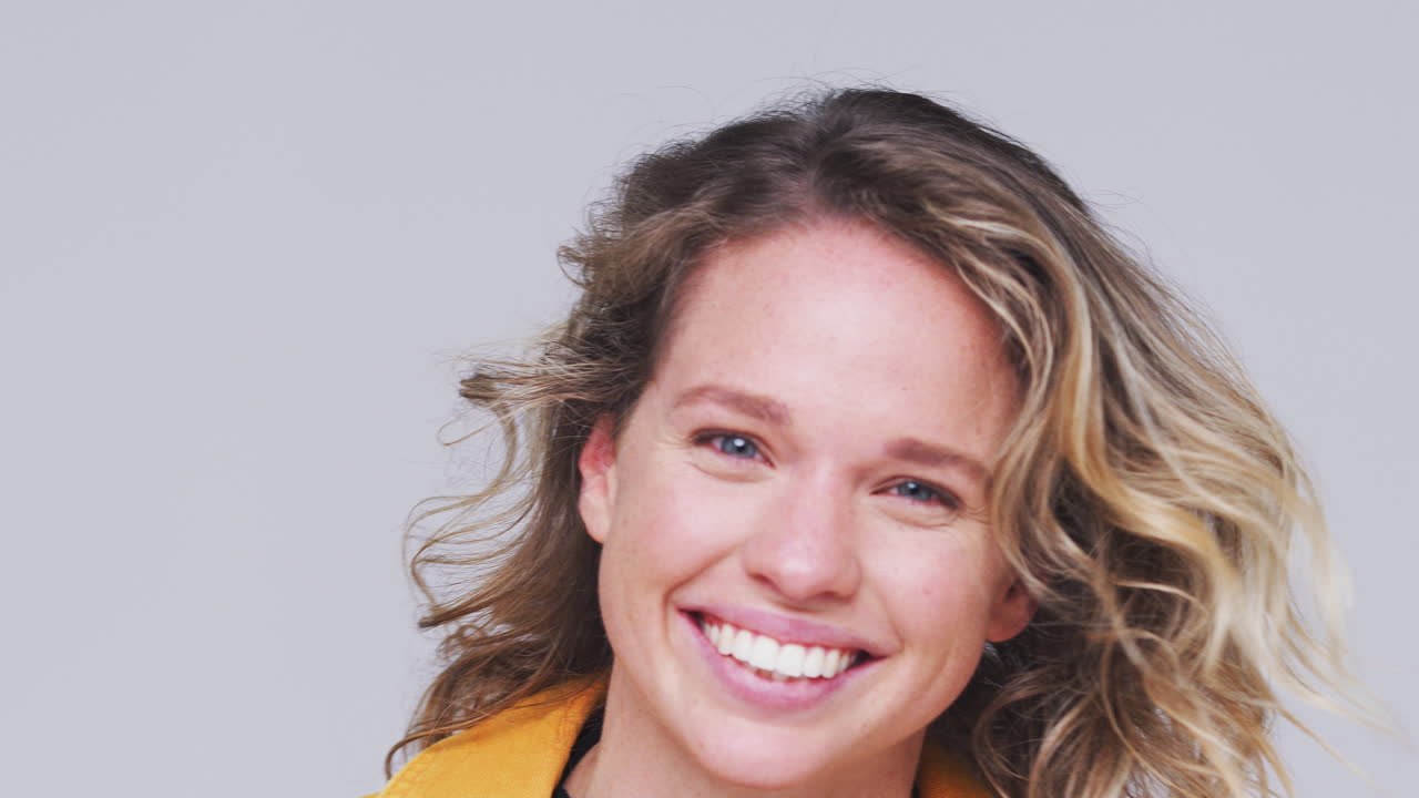 Studio Shot Of Woman Appearing From Bottom Of Frame Laughing At Camera In Slow Motion