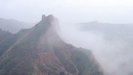 mountain ridge near river on foggy day