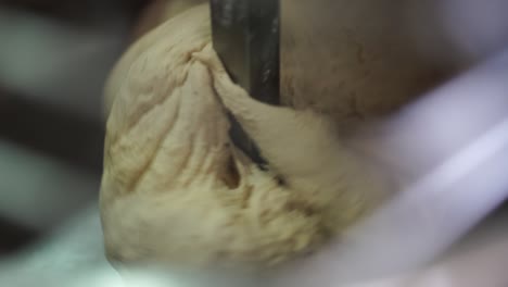 extreme close-up of bread dough in an industrial mixer