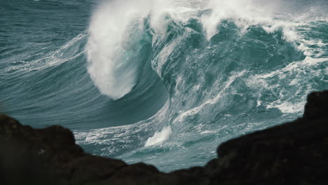 Foamy-wave-breaks-in-glass-like-slow-motion-behind-the-rock-shelf