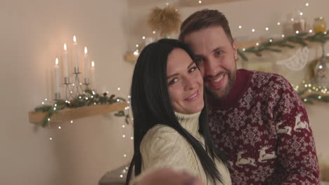 Amorosa-Pareja-Caucásica-Tomando-Un-Video-Selfie-Y-Saludando-A-La-Cámara-En-Navidad-En-Casa