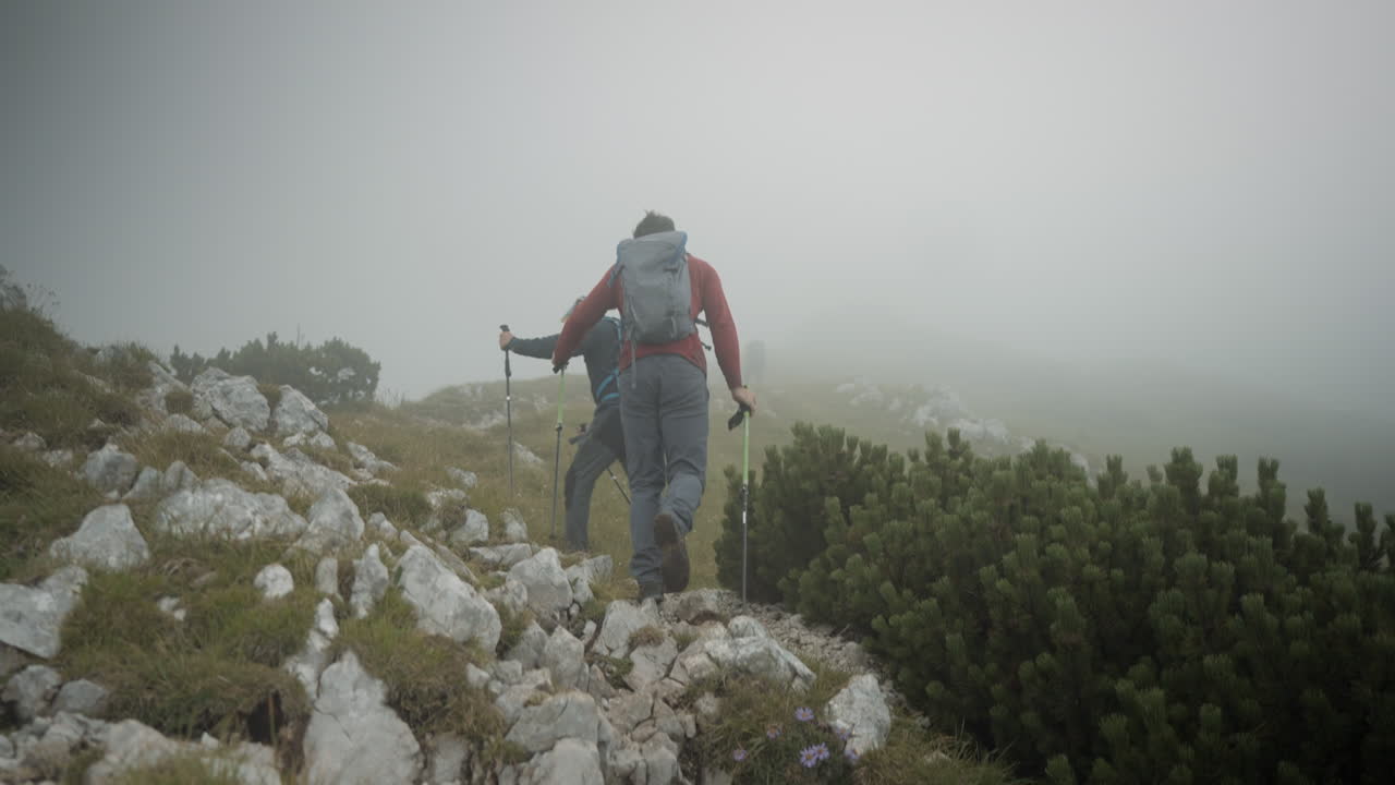 cámara rastreando a dos excursionistas en el camino hacia la cima de la montaña stol