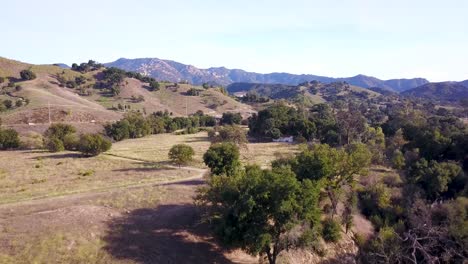 Panning-Aerial-shot-of-Santa-Monica-Mountains-in-Los-Angeles,-California-at-sunset-on-a-warm-sunny-day