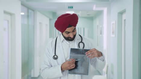 happy sikh indian doctor explaining x ray report to patient