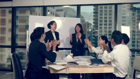 successful asian business people celebrate project success in group meeting.