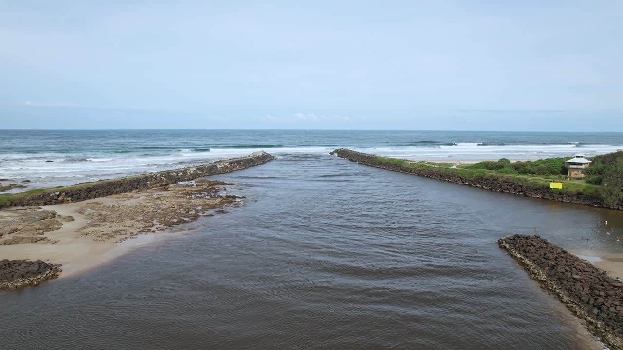 Brunswick River Flowing Into The Ocean Between Breakwalls In New South Wales, Australia. wide aerial shot