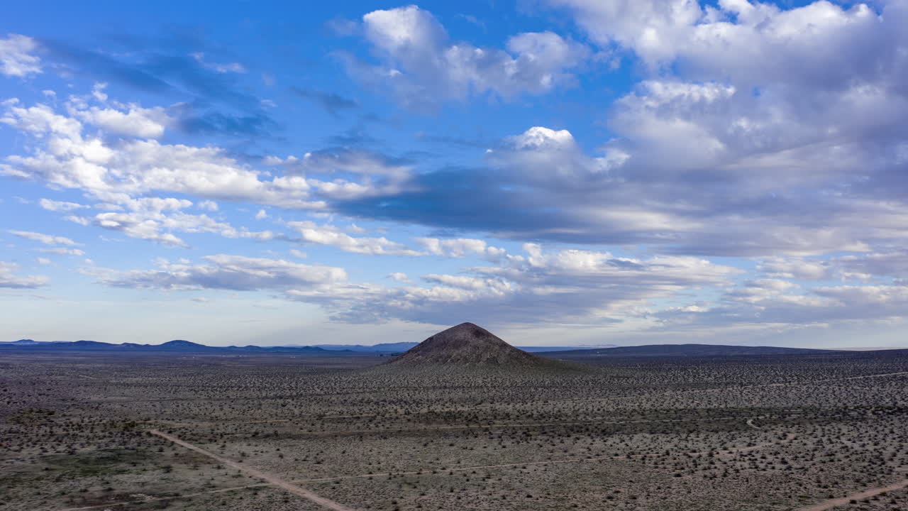 Dramatic landscape timelapse with fluffy clouds, beautiful blue sky and barren land.