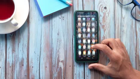 person using a smartphone on a wooden table