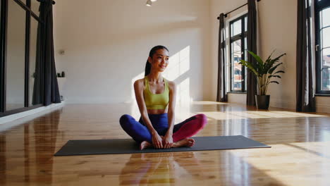 mujer practicando yoga en un estudio