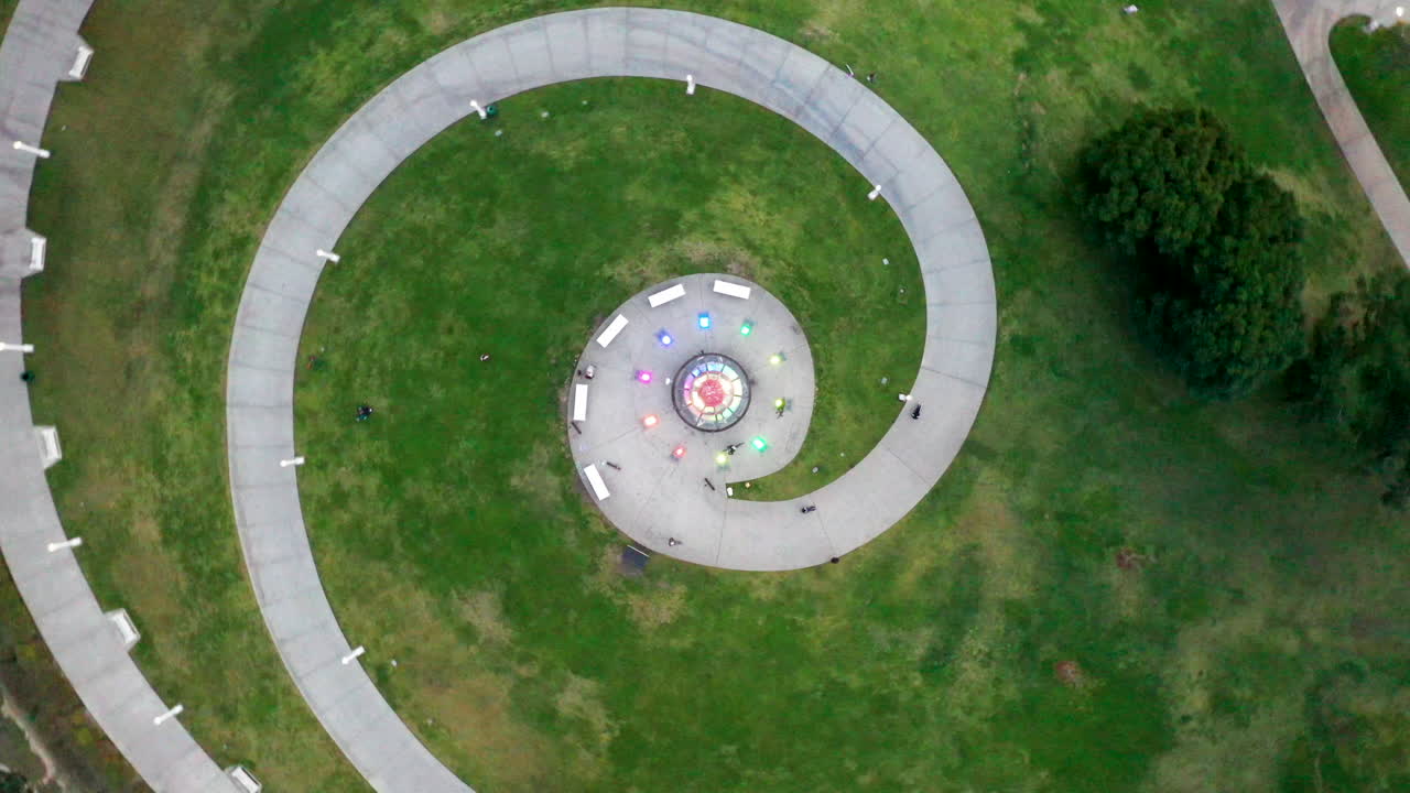 Spiral aerial shot of Long Beach Lighthouse, California, USA. Dusk shot of the lighthouse with people on bikes riding the path that snakes round the lighthouse near the water