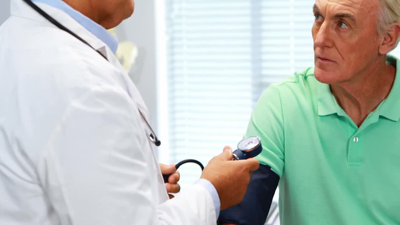 médico que controla la presión arterial de un paciente