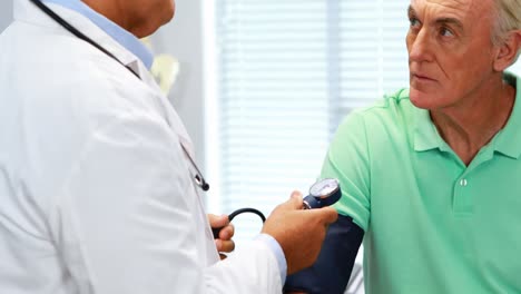 doctor checking blood pressure of a patient