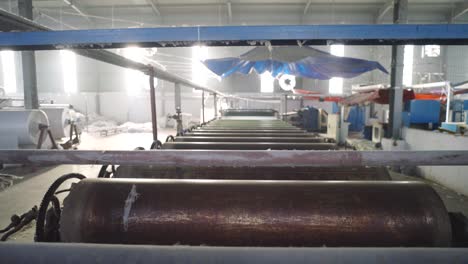 filas de grandes tambores giratorios dentro de una fábrica textil en pakistán