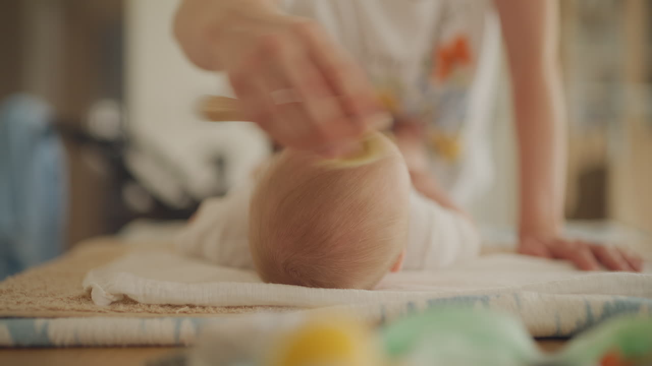 Mother brushing baby's hair