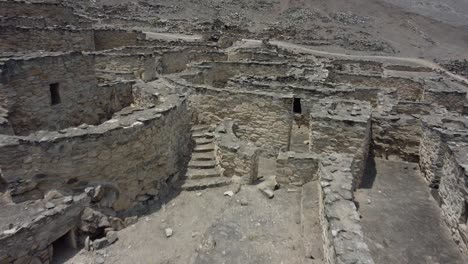 Drone-shot-of-a-500-year-old-abandoned-stone-town-on-a-rocky-mountain-side