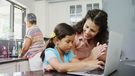 Mother-and-daughter-using-laptop-in-kitchen-4k