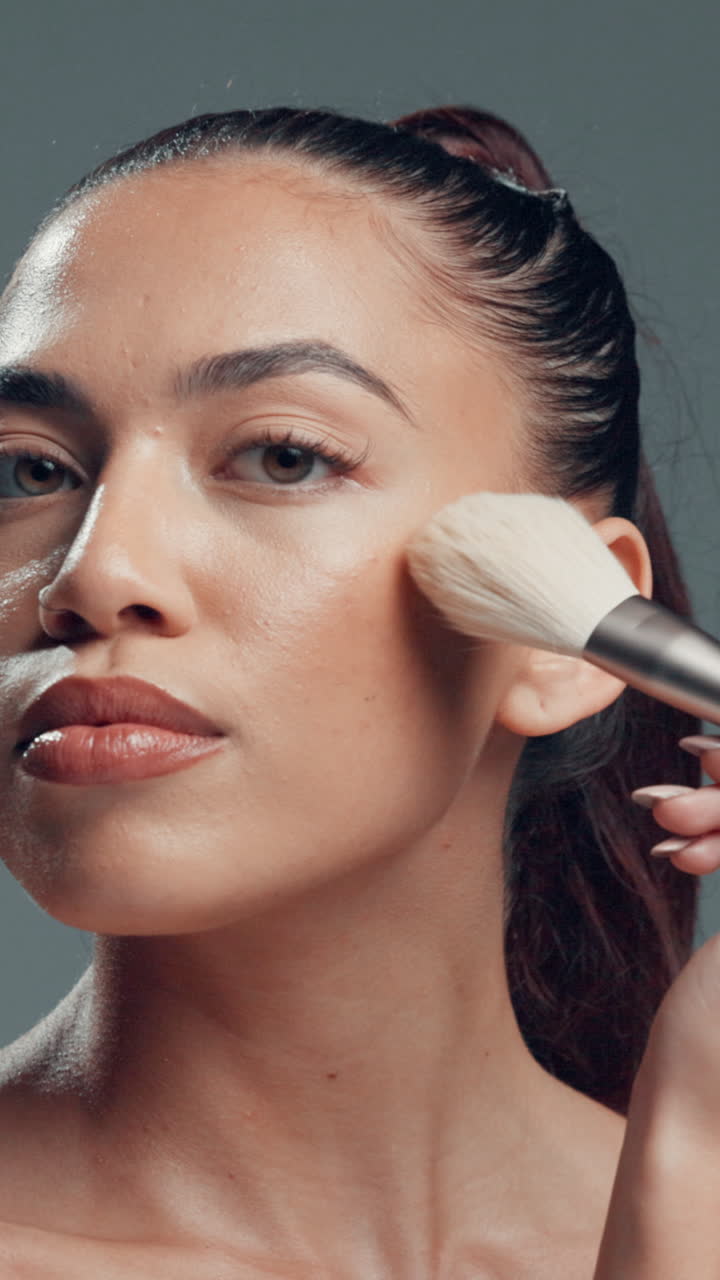 Young Woman Applying Makeup with a Brush to Her Cheek
