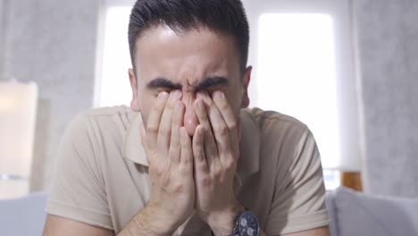 un hombre triste llorando en casa.