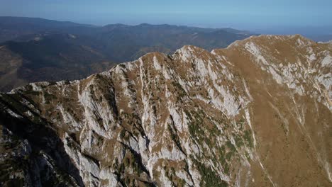 Toma-Aérea-Del-Pico-La-Om-En-Las-Montañas-Piatra-Craiului-Con-Un-Cielo-Despejado-Al-Mediodía