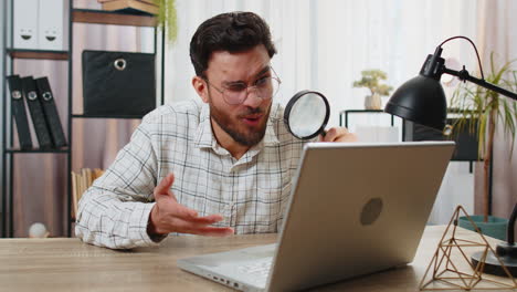 hombre de negocios sorprendido trabajando en una computadora portátil con una lupa wow expresión de búsqueda de análisis