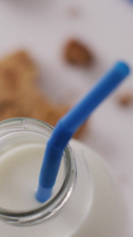 video of glass bottle of milk and cookies on white background