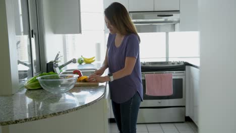 mujer cortando verduras en la cocina 4k