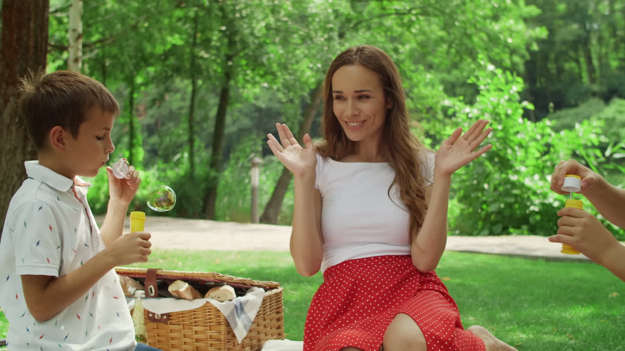 엄마와 아이들이 비누 거품으로 놀고 있습니다.