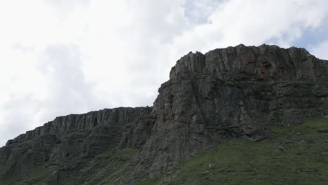 Vuelo-Aéreo-Hacia-Escarpados-Acantilados-Rocosos-Fuera-De-La-Meseta-Verde-De-La-Montaña.