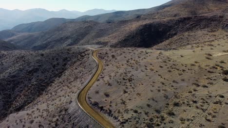 Gravel-road-twists-and-turns-through-scrubby-arid-hillsides-of-Chile