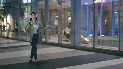 happy woman dancing in a shopping mall at night