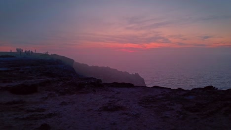 tourists enjoying sunset from cabo de san vicente headland of vila do bispo, portugal