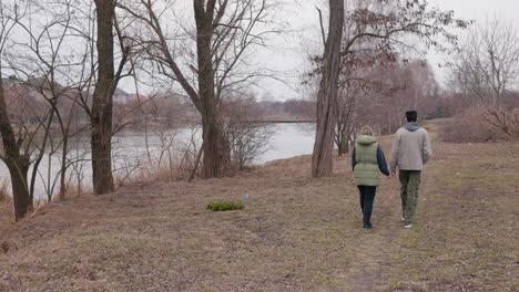 couple walking by the river in a park