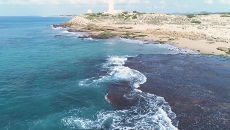 Antena:-La-Costa-Turquesa-De-Cádiz,-España,-Mientras-Las-Olas-Salpican-Las-Rocas