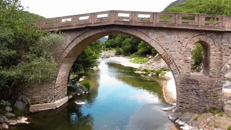 aerial 4k shot of old stone bridge and river pilima xanthi greece-3