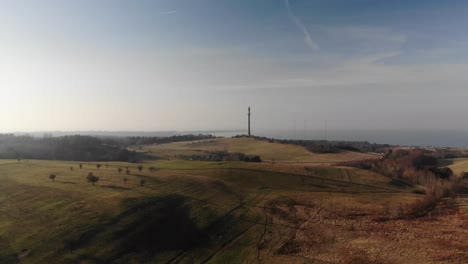 Aerial-view-of-beautiful-green-hills-,-moving-toward-the-sunset-in-Sejerøbugten,-Denmark