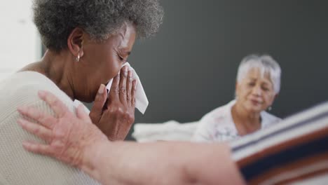 diverse group of senior friends giving support to african american female friend on meeting