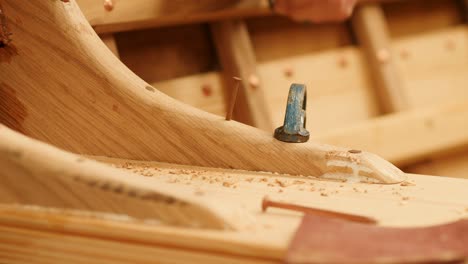 close up: nailing wooden seat knee in boat building project