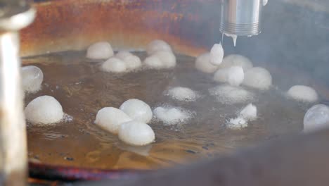 deep fried doughnuts cooking in hot oil