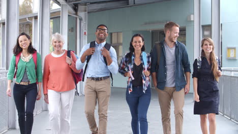 Gruppe-Glücklicher-Schullehrer,-Die-Im-Korridor-Zur-Kamera-Gehen