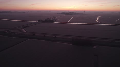 Wide-shot-of-dutch-rural-countryside-with-colorfull-sky-during-sunrise,-aerial