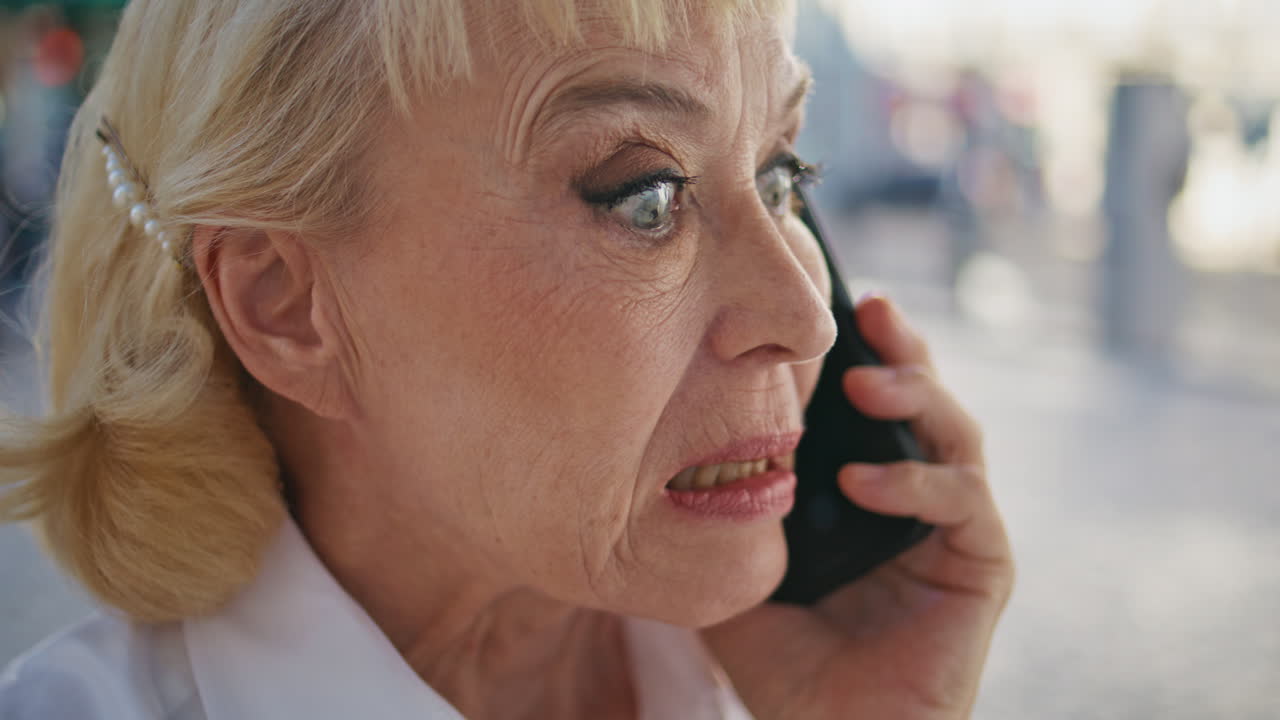 Yakın çekim gergin emekli, akıllı telefonla arama yaparken olumsuz duygular ifade ediyor.